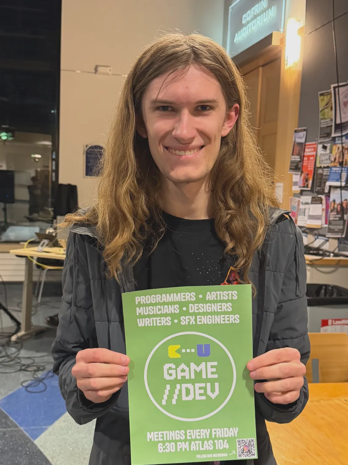 Declan holding a Game Dev Club poster