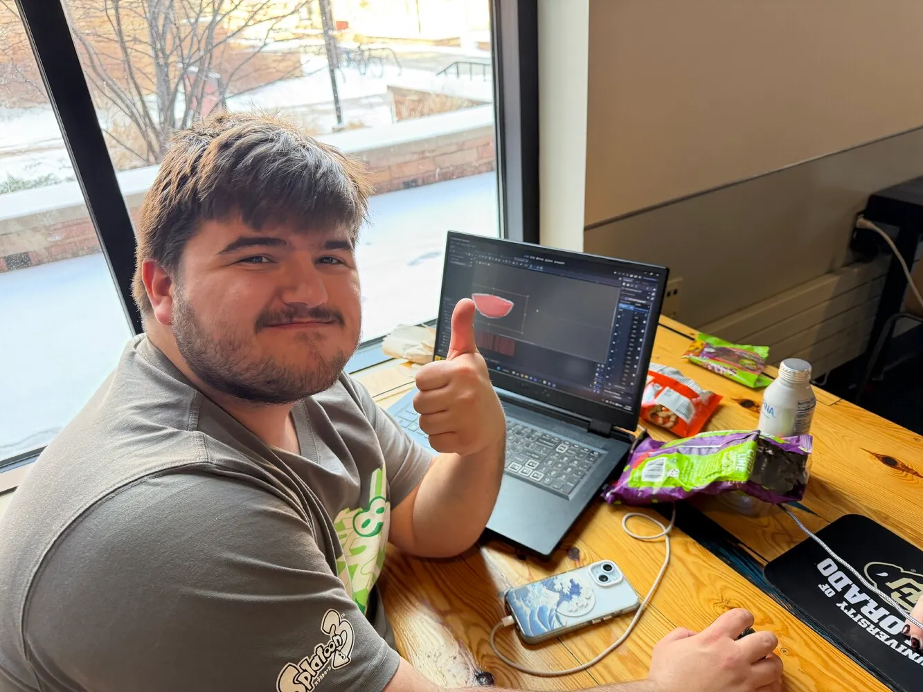 Jaden smiling at the camera in front of his laptop